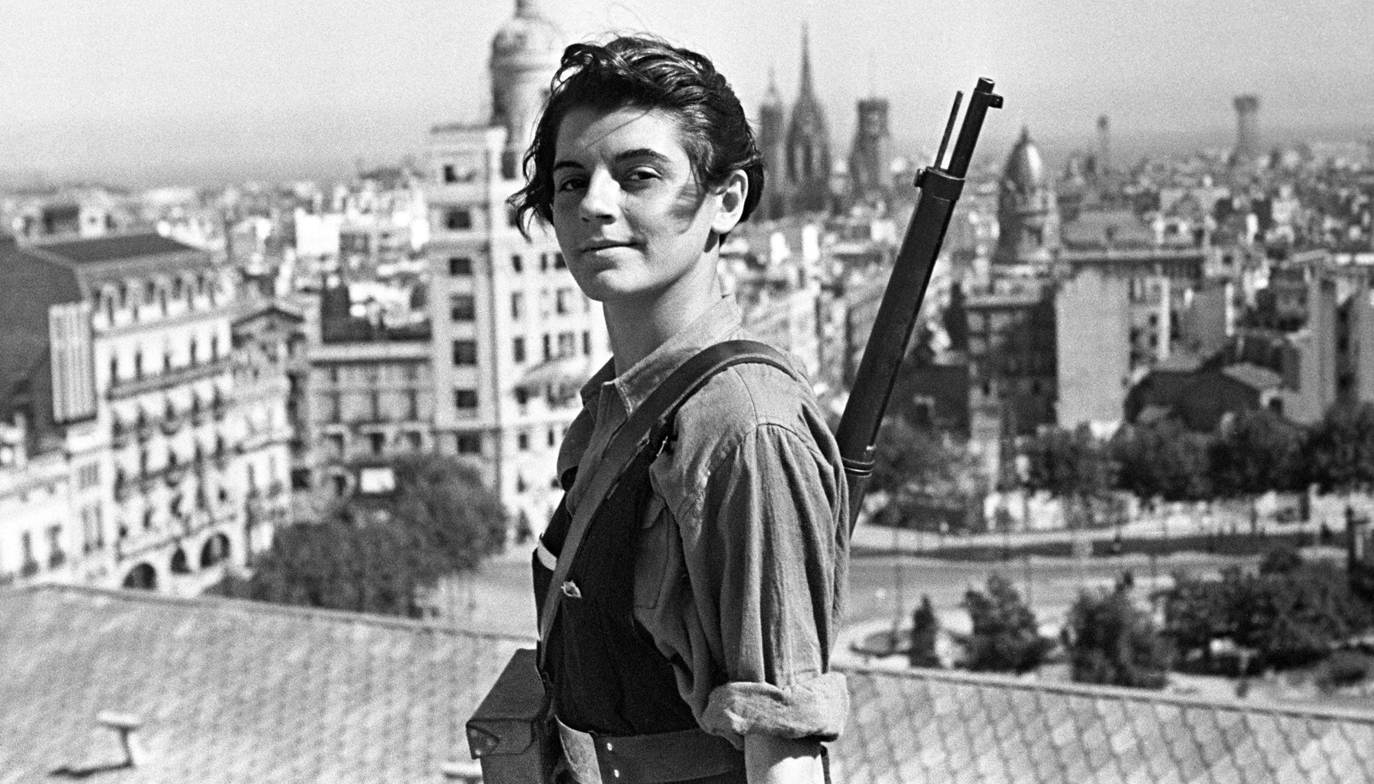 Iconic photo of a female Spanish revolutionary: The famous 1936 portrait of Marina Ginestà. Taken by photographer Juan Guzmán on the roof of Barcelona's Hotel Colón, the image shows the 17-year-old anti-fascist militant smiling defiantly while overlooking the city with a Spanish Mauser rifle.